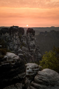 Scenic view of cliff against sky during sunset