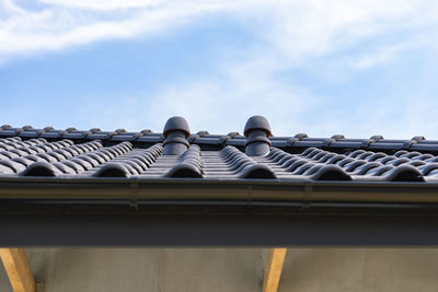 Low angle view of building roof against sky