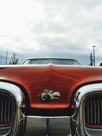 Cars on road against cloudy sky