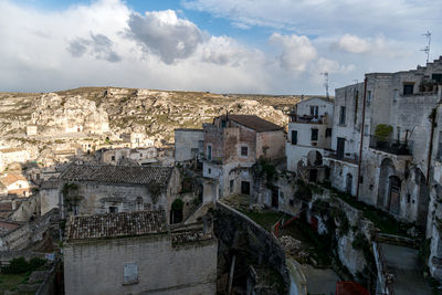 Buildings in town against cloudy sky