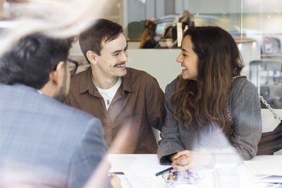 Smiling couple meeting with real estate agent in office