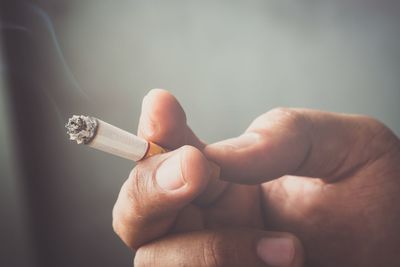 Close-up of hand holding cigarette