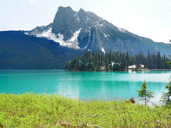 Scenic view of lake by mountains against sky