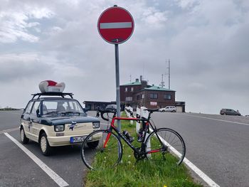 Bicycle on road against cloudy sky