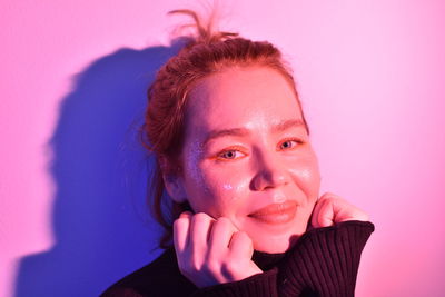 Portrait of young woman against yellow background