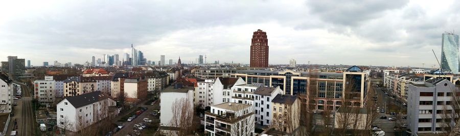View of cityscape against cloudy sky
