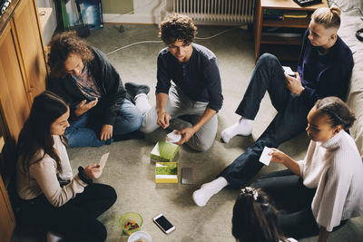 High angle view of people sitting on mobile phone