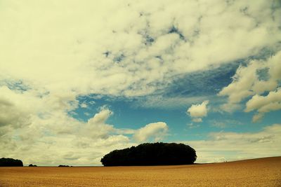 Scenic view of field against cloudy sky