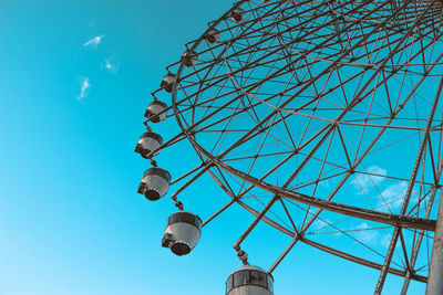 Low angle view of electricity pylon against blue sky