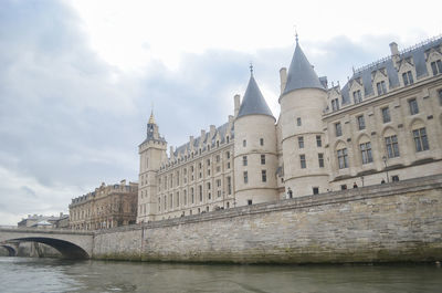 Arch bridge over river against buildings in city