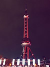 Low angle view of illuminated buildings against sky at night