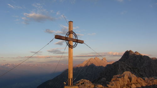 Windmill on mountain against sky during sunset