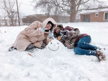 People sitting on snow covered field