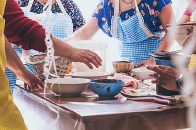 Midsection of women preparing food at table