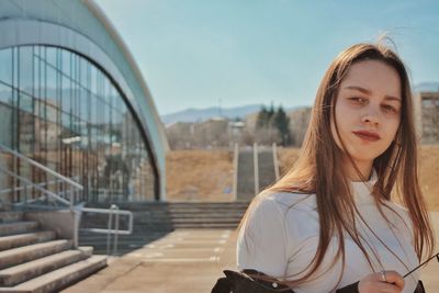 Portrait of a beautiful young woman against sky