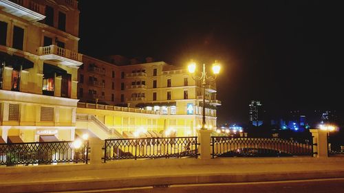 Illuminated city against clear sky at night