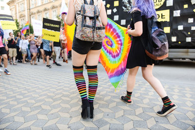 Low section of people on multi colored umbrella