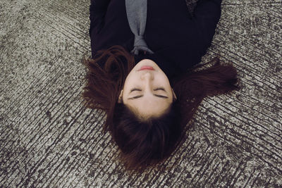 Close-up of woman lying on road