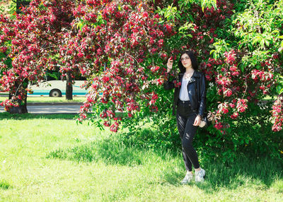 Young girl standing near cherry blossoms in spring