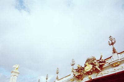 Low angle view of flowering plants by building against sky