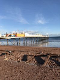 Pier on beach against sky