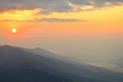 Scenic view of mountains against orange sky