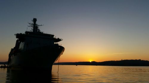 Boats in sea at sunset