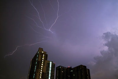 Low angle view of illuminated buildings against sky at night