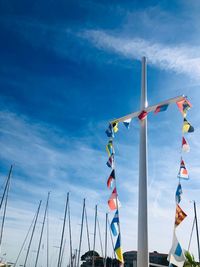 Low angle view of flags against blue sky