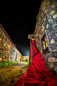Low angle view of illuminated cross against sky at night