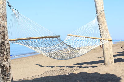 Metallic structure on beach against clear sky