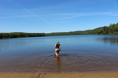 Rear view of man in water against sky