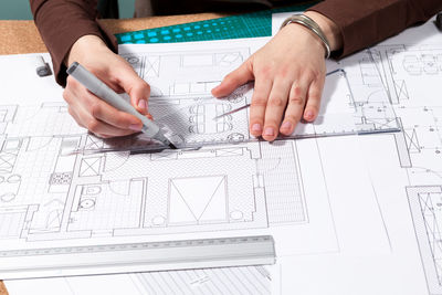 Midsection of businessman working on blueprint