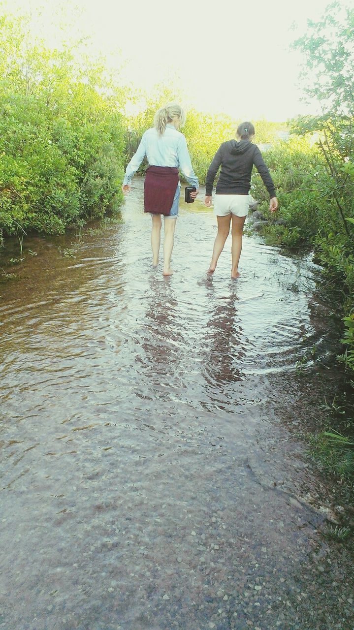 water, lifestyles, leisure activity, waterfront, reflection, lake, tree, men, day, person, full length, rear view, walking, river, outdoors, low section, rippled, standing