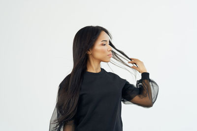 Young woman looking down against white background