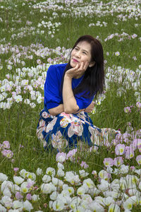 Smiling young woman sitting on field