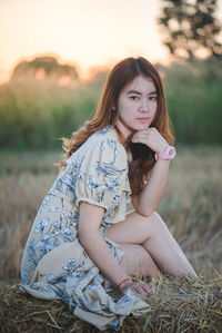 Portrait of woman sitting on field