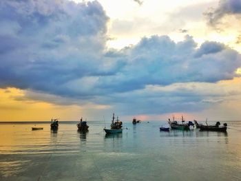 Boats in sea against sky during sunset