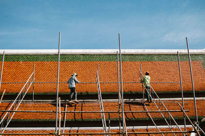 Construction workers standing on roof of building