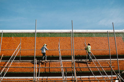 Construction workers standing on roof of building