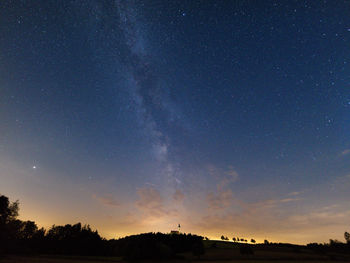Low angle view of silhouette trees against sky at night