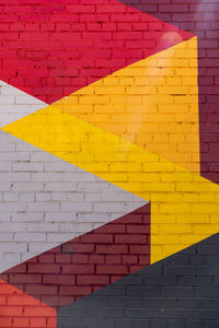 Colorful grey, red, yellow brick wall as background, texture