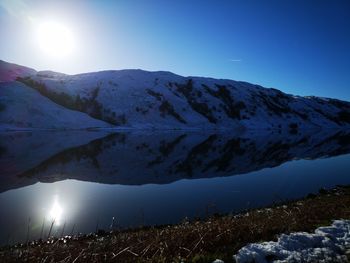 Scenic view of snowcapped mountains against clear blue sky