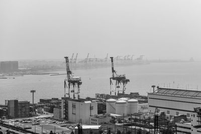 High angle view of cranes against buildings in city