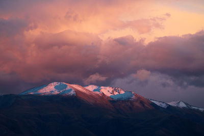 Scenic view of snowcapped mountains against sky during sunset