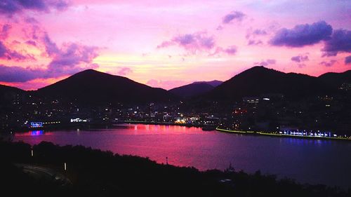 Scenic view of lake against cloudy sky at sunset