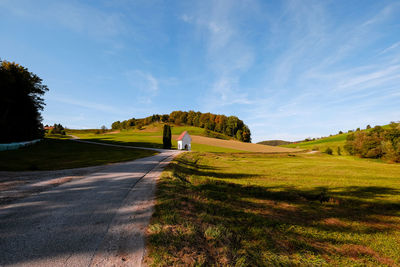 Road amidst green landscape against sky