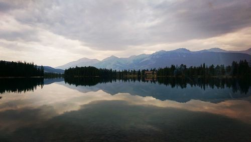 Scenic view of cloudy sky and mountains relfected in calm lake