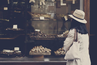 Rear view of woman looking at food store