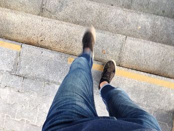 Low section of man moving down on steps